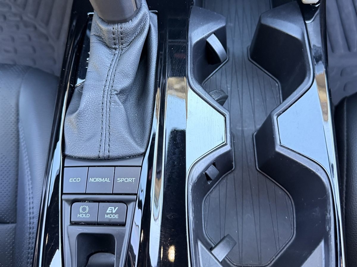 The same center console after detailing: gloss-black trim and cupholders wiped clean
