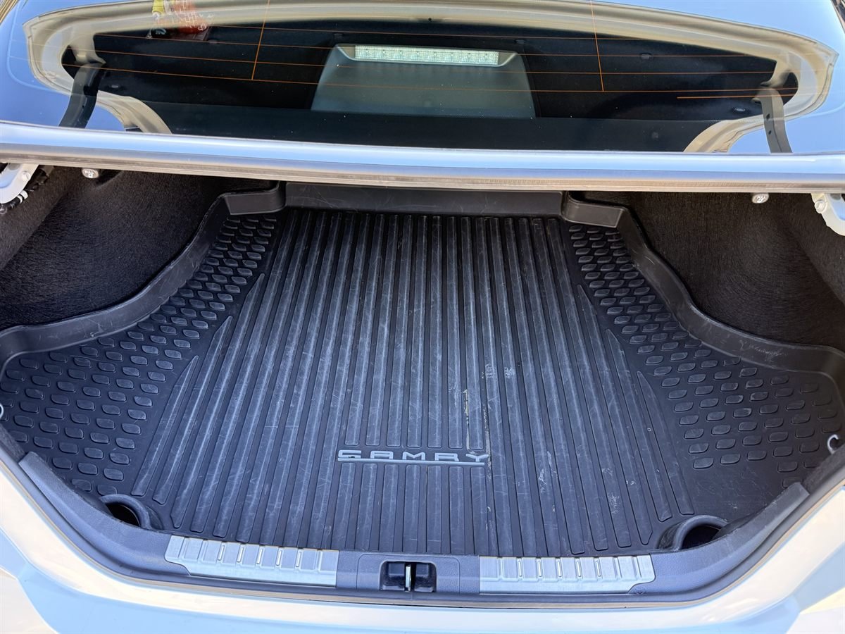 The same Camry trunk after detailing: litter removed and the rubber trunk mat cleaned